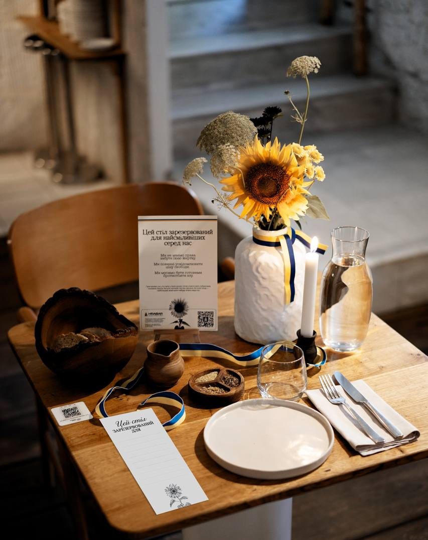A Table of Memory in one of the 3,000 restaurants, cafés, and cultural venues across Ukraine that joined the initiative to honour fallen defenders. Tables were reserved for the entire day “for the bravest among us” and set with sunflowers as a symbol of remembrance. Photo by Memorial.ua.
